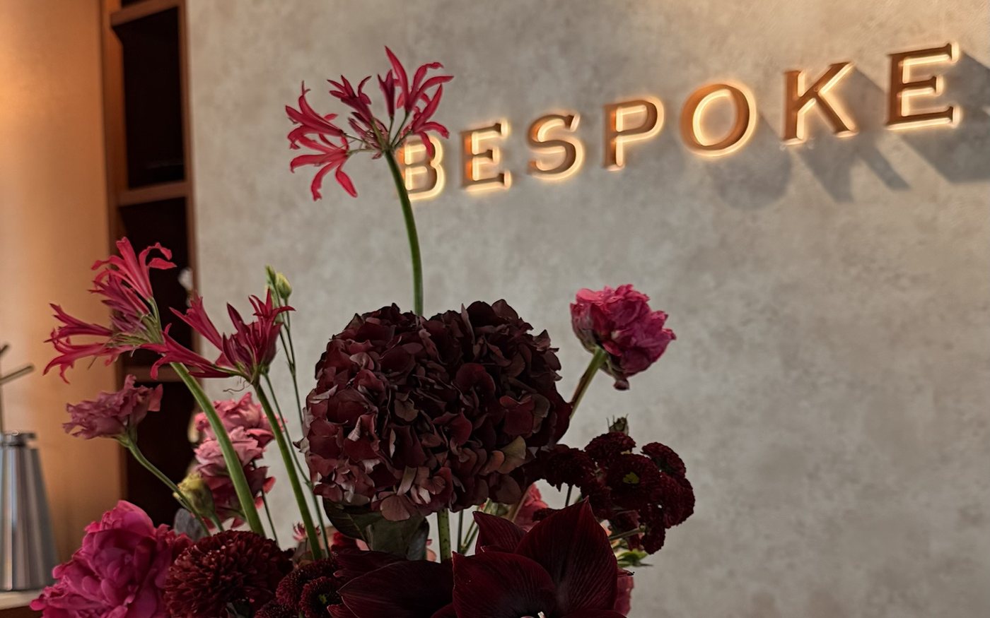The Bespoke atelier, with a burgundy floral arrangement on the marble reception