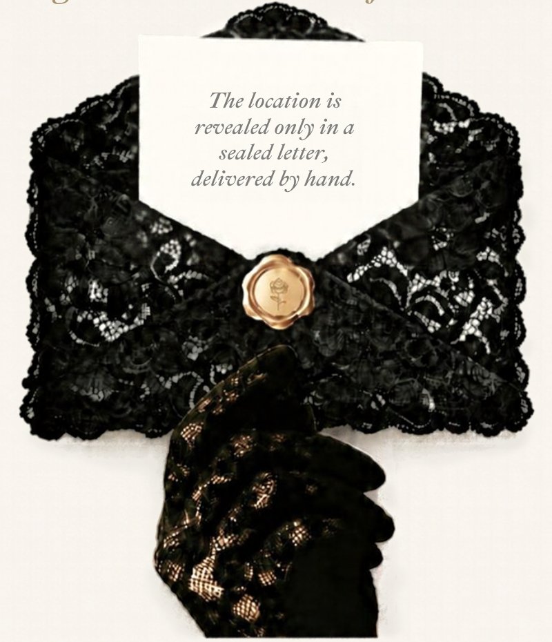 A black lace envelope sealed with a gold wax rose, held by a gloved hand, an ivory card inside